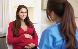 Pregnant woman consulting with healthcare professional.