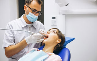 Dentist performing dental exam on patient in clinic.